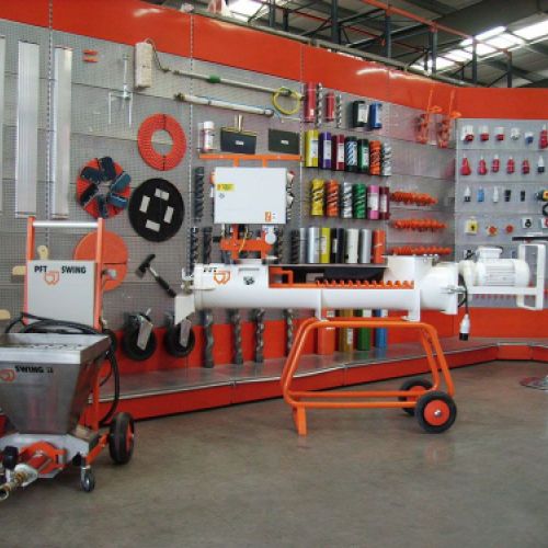 Varias estanterías con material de pintura y construcción en interior de almacén