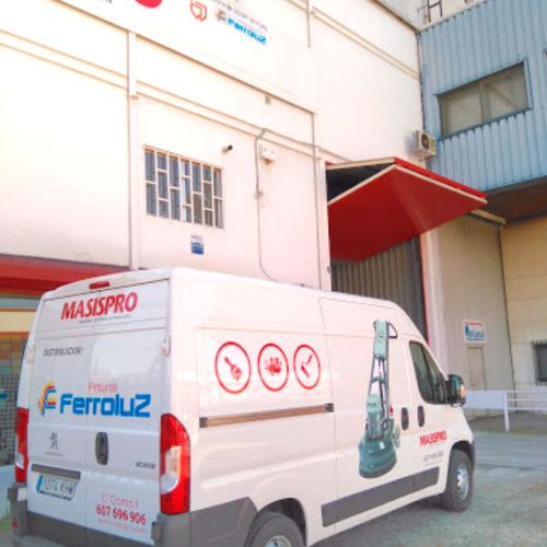 Exterior de la tienda con furgoneta con logotipo rotulado