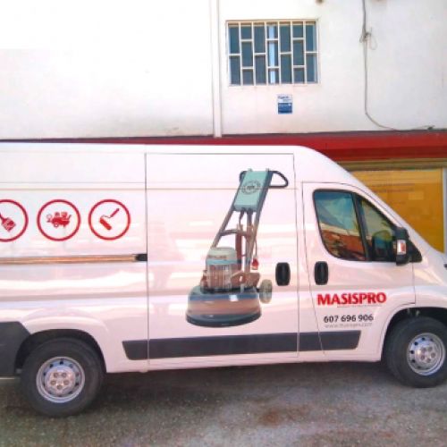 Vista lateral de la furgoneta rotulada en exterior de almacén