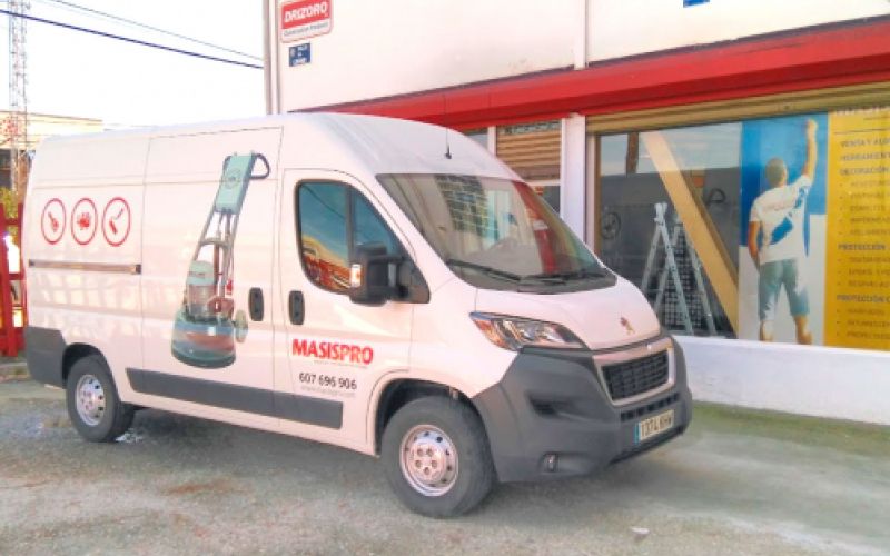 Escaparates del exterior de la tienda con furgoneta rotulada en la puerta