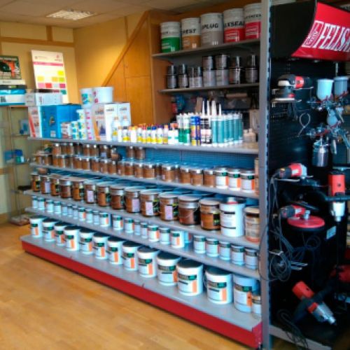 Estantes con materiales de pintura en interior de la tienda