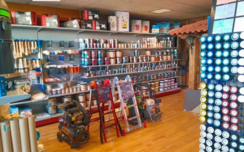 Interior de la tienda con varios estantes con materiales de pintura y cnstrucción