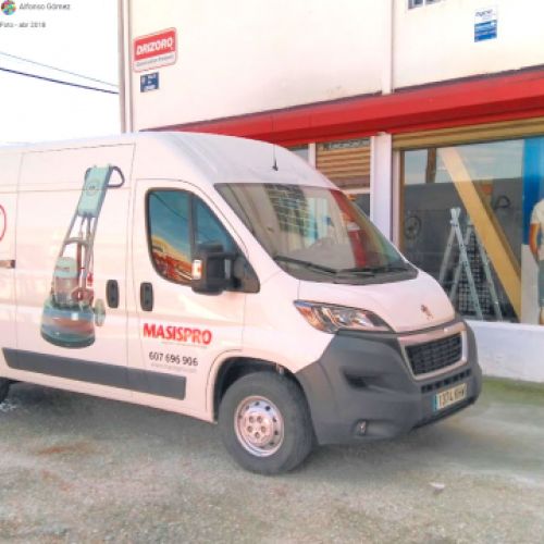 Escaparates del exterior de la tienda con furgoneta rotulada en la puerta